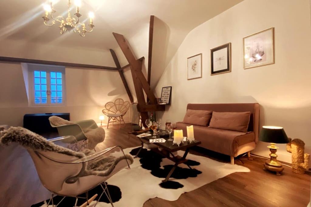 uma sala de estar com um sofá e uma mesa em Grand appartement place Saint-Pierre, proche Château de Saumur et bord de Loire" em Saumur