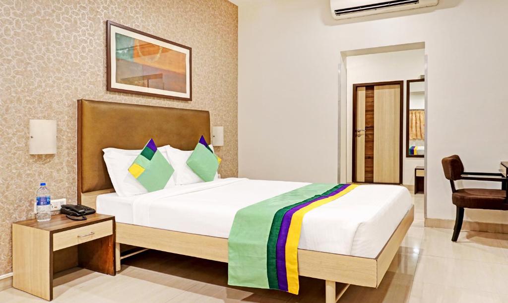 a hotel room with a bed and a desk at Hotel Madhav International Pune Railway Station in Pune
