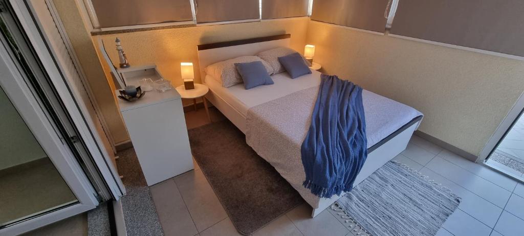 a small bedroom with a bed with blue pillows at Two stars - Villa Sunce in Senj