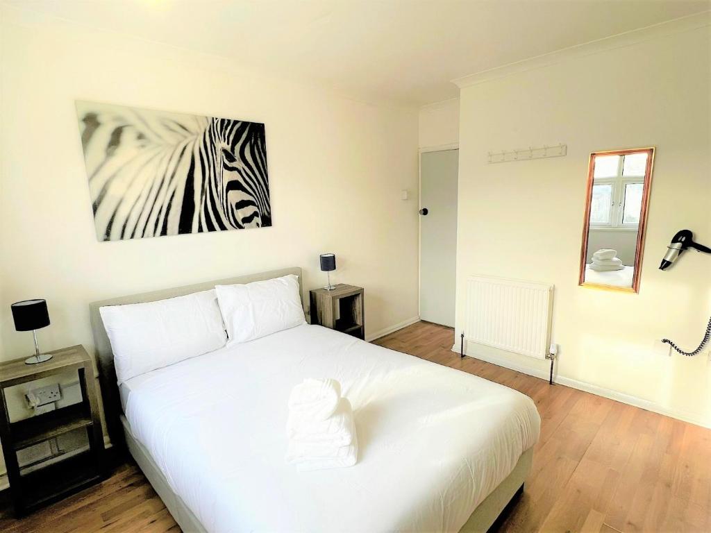 a bedroom with a white bed with a zebra picture on the wall at Stepney Green Comfy Double bed rooms 14 in London