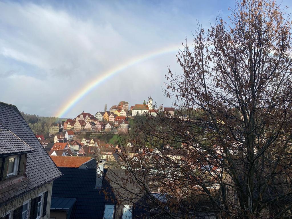 um arco-íris no céu sobre uma cidade com casas em Retro Ferienwohnung mit Schlossblick im Nordschwarzwald em Altensteig