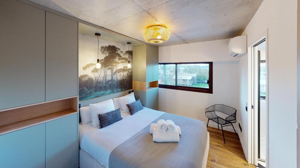 1 dormitorio con 1 cama blanca grande y 1 silla en Villa Ananda - Gâia - Harmonie avec vue mer et étangs, en Carnon-Plage