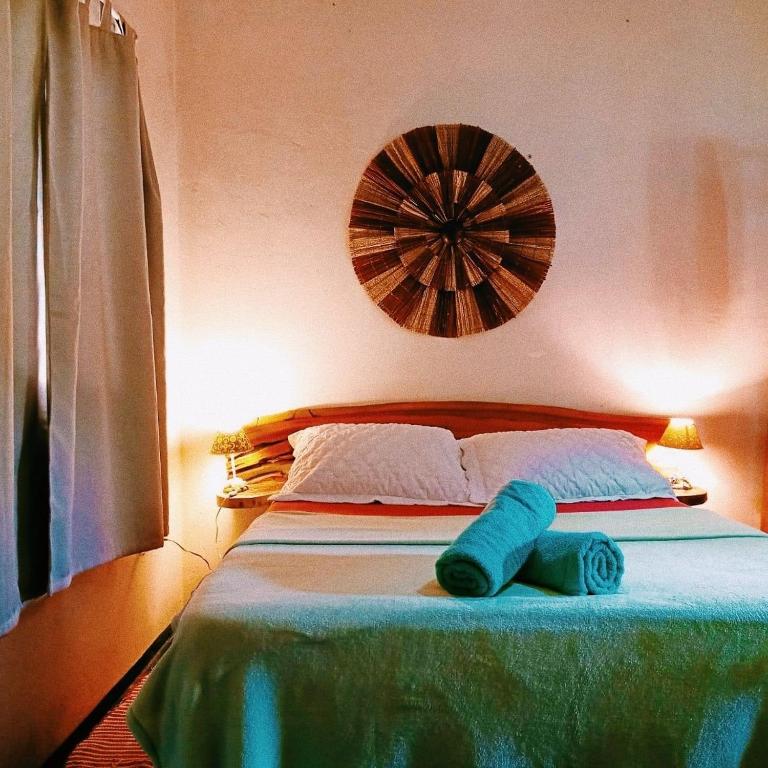 a bed with two blue towels on top of it at Villa Ágape - Chapada dos Veadeiros in Alto Paraíso de Goiás