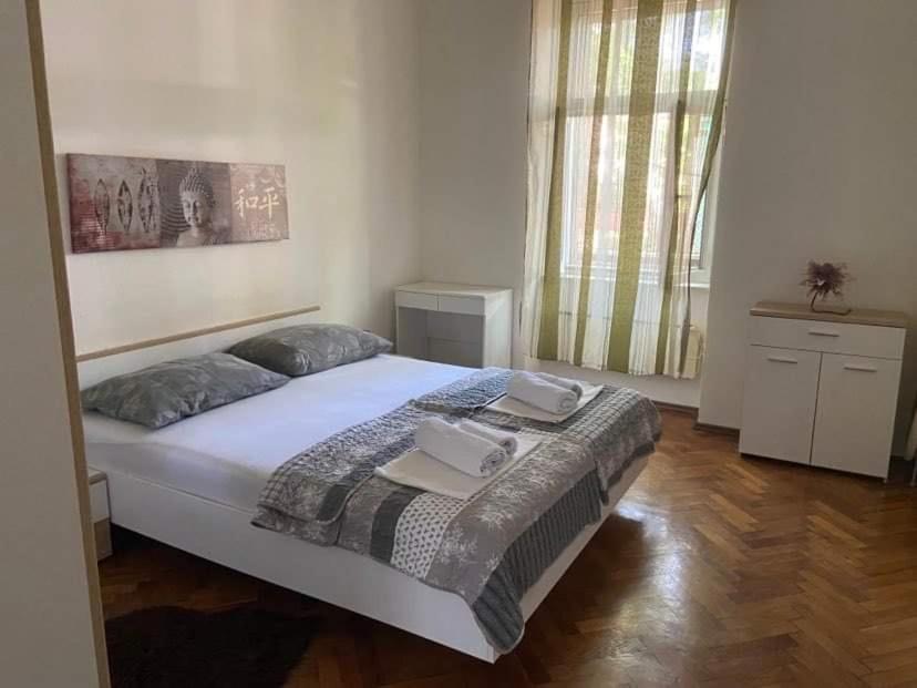 a bedroom with a large bed with two pillows at Alex in Rijeka