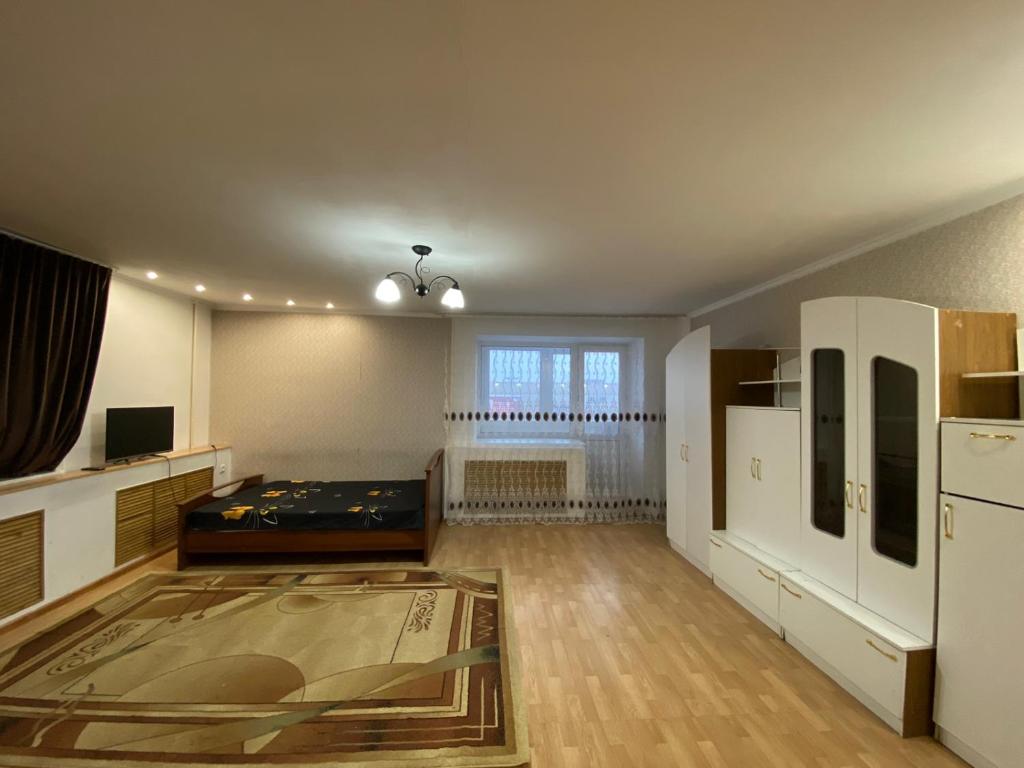 an empty living room with a bed and a window at Сдам квартиры посуточно in Kokshetau
