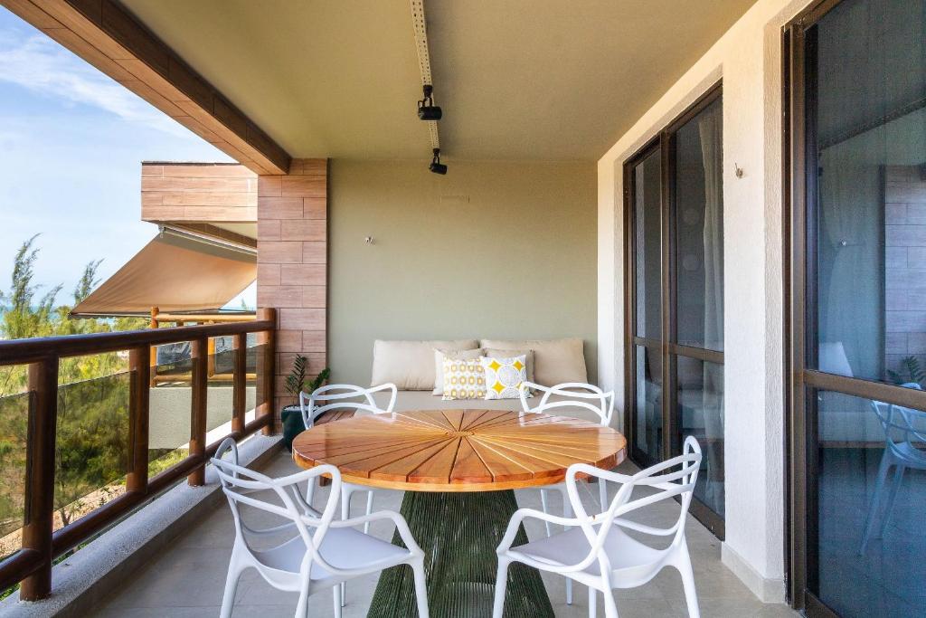 d'une terrasse avec une table et des chaises sur un balcon. dans l'établissement Apartamento Lindo e Completo - Wai Wai Cumbuco, à Cumbuco