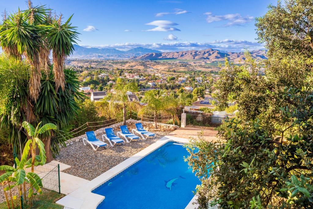 アラウリン・デ・ラ・トレにあるLovely Home Las Mañanas - Piscina, barbacoa y vistas Ideal Familiasの山々の景色を望むプール(椅子付)