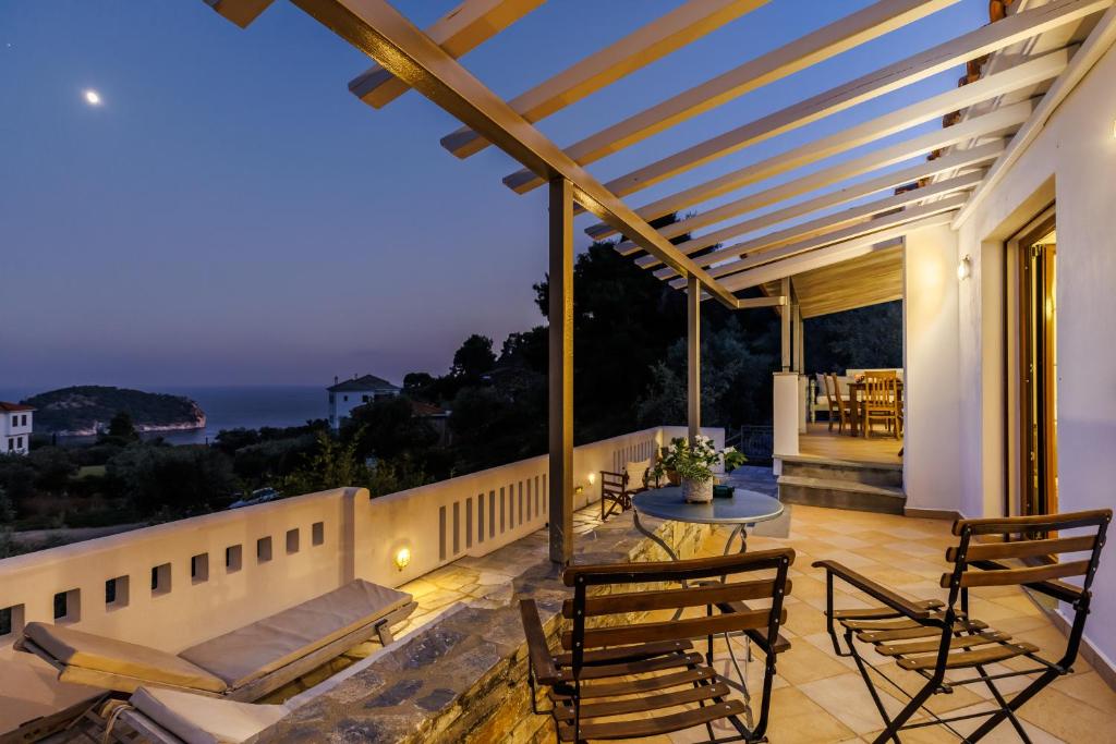 a patio with a view of the ocean at night at Irida House in Stafylos