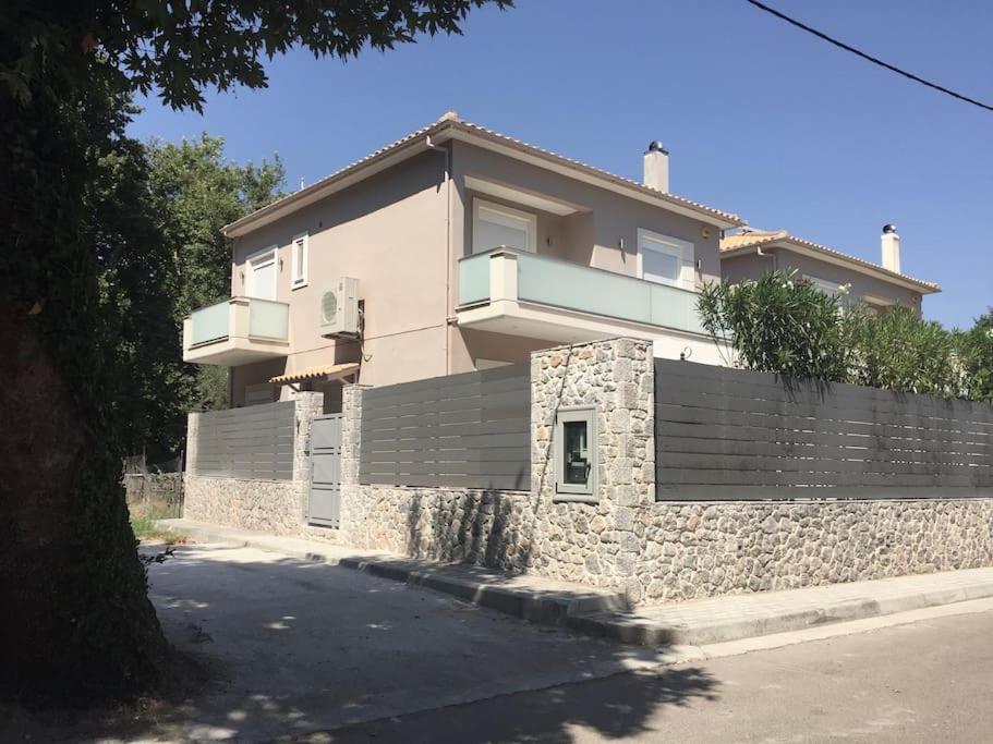 une maison avec un mur en pierre et une clôture dans l'établissement Villa Oleander Agios Nikolaos Loutra Edipsou, à Loutra Edipsou