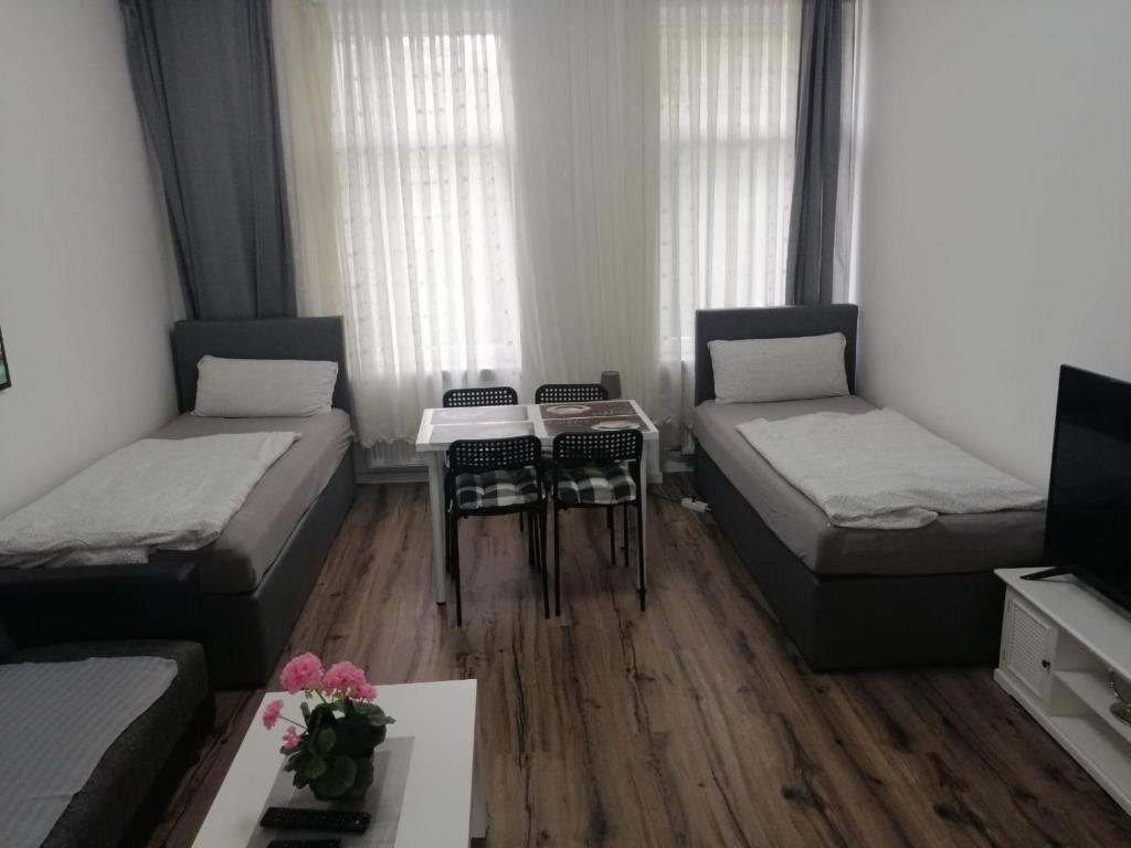ein kleines Zimmer mit zwei Betten und einem Tisch in der Unterkunft Wohnung in Köln 1B in Köln