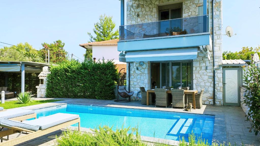 a house with a swimming pool next to a house at Villa Marietta The First in Hanioti