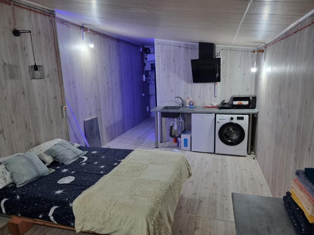 a bedroom with a bed and a washing machine at In the heart of the city Chisinau in Chişinău
