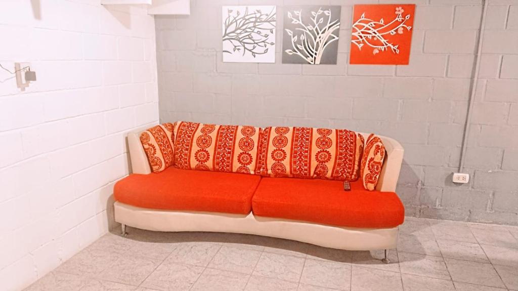 Sofá rojo en una habitación con pared en El Descanso en San Luis