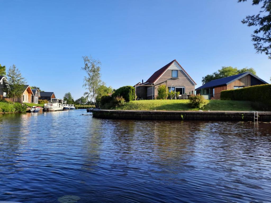 einen Fluss mit Häusern an der Seite in der Unterkunft Waterhuis Friesland in Oudwoude