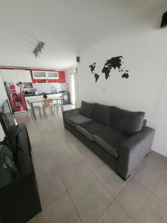 a living room with a couch and a world map on the wall at Departamento Completo y muy buena ubicación in Tandil