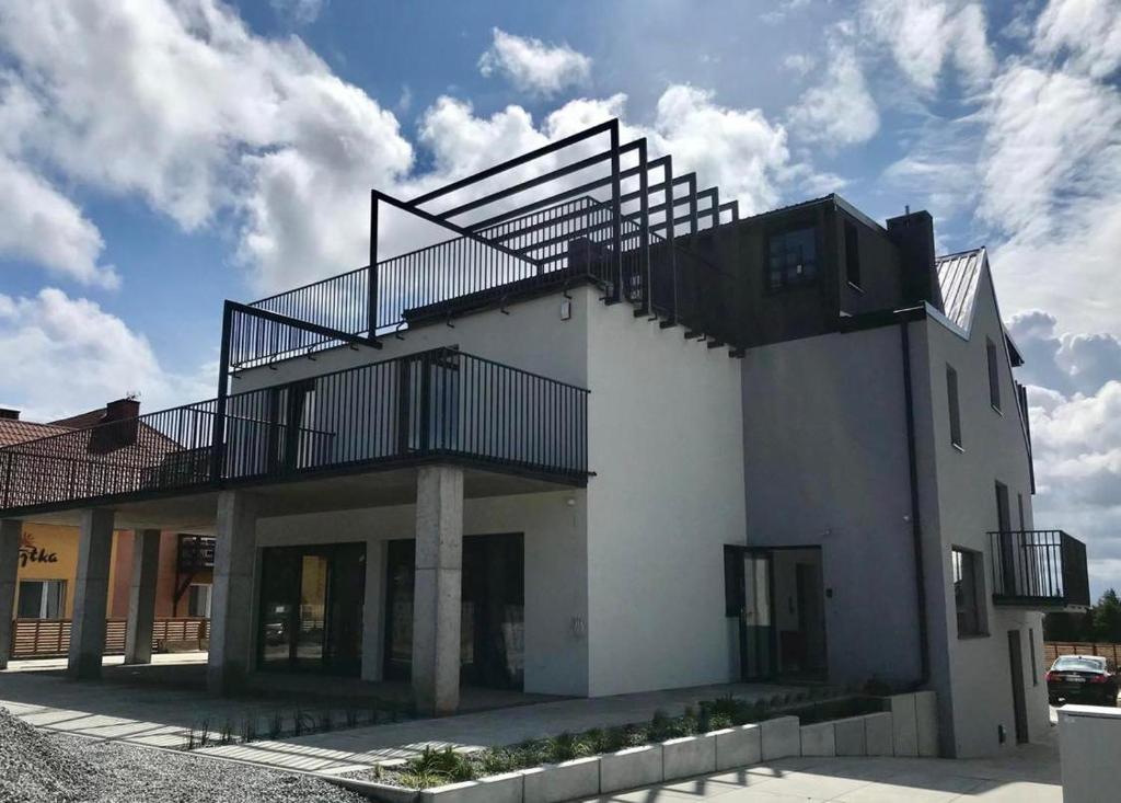 a white building with stairs on top of it at BLOMMA Niechorze in Niechorze