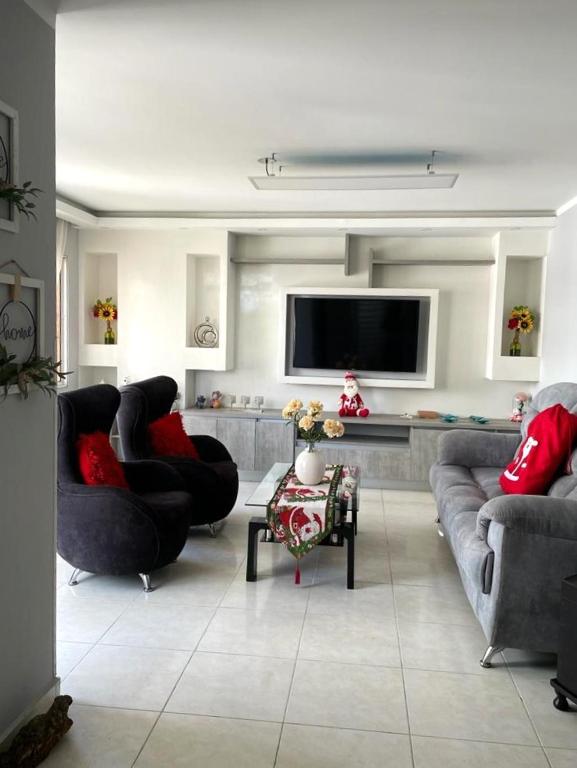 a living room with couches and a flat screen tv at Apartamento en Cañaveral in Floridablanca