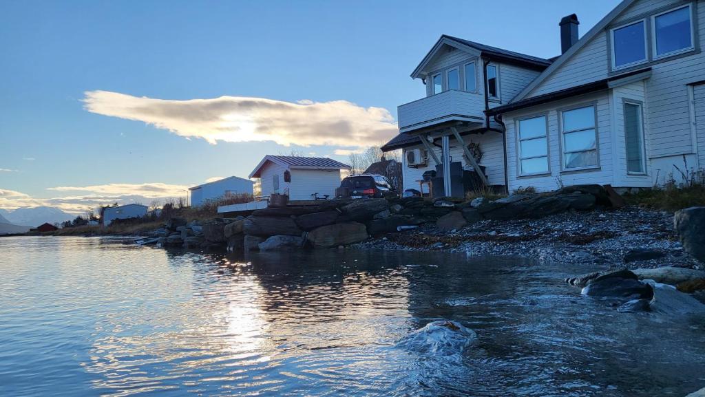 a group of houses next to a body of water at Arctic Sea house in Svensby