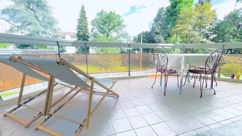 a patio with two chairs and a table on a balcony at Voiron centre, grande terrasse, parking, calme in Voiron