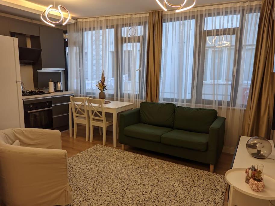 salon z zieloną kanapą i kuchnią w obiekcie Modern Apartment in the Heart of the City - Fatih w Stambule