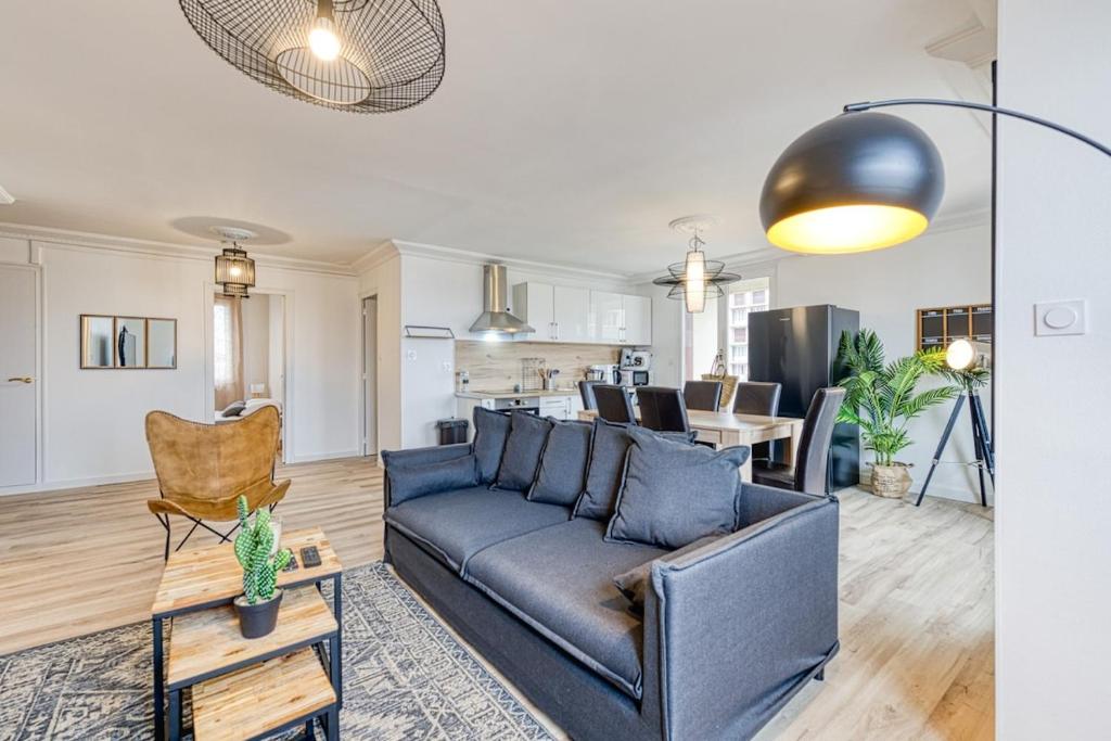 Il comprend un salon avec un canapé bleu et une cuisine. dans l'établissement Magnificent apartment, 4 bedrooms, fiber wifi, à Grenoble