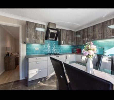 a kitchen with a vase of flowers on a counter at Rainbow Quays in London