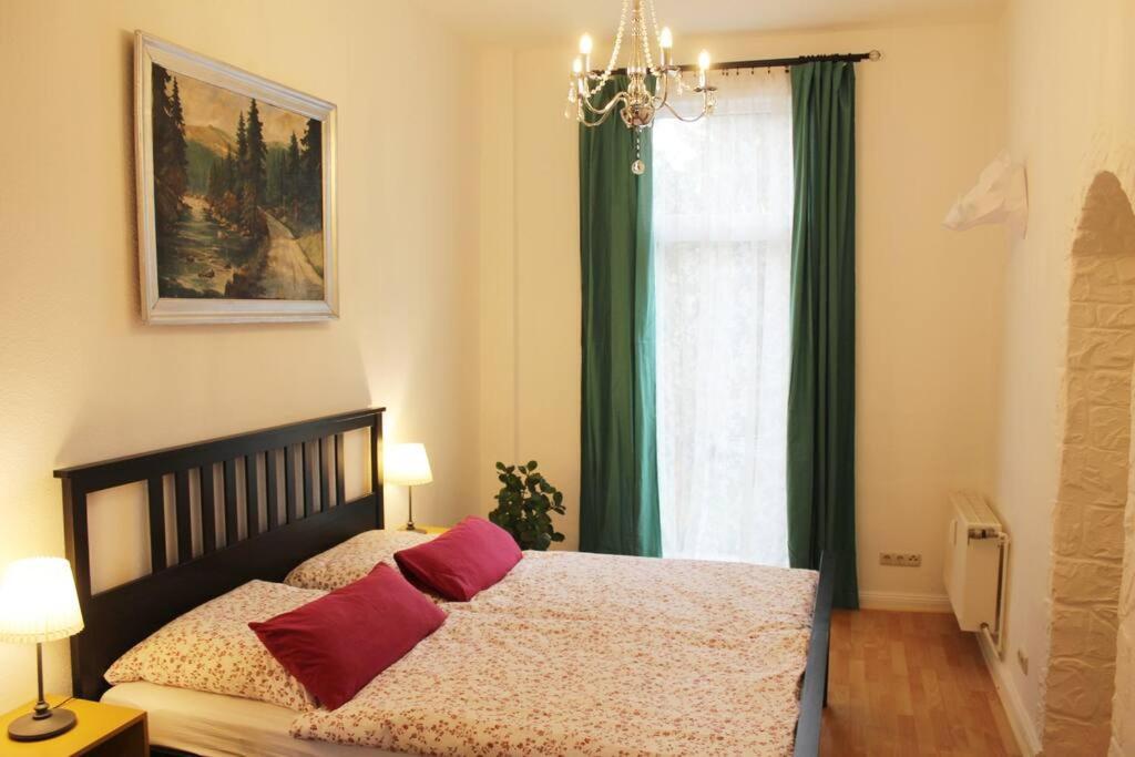 a bedroom with a bed with red pillows and a window at Wiesengrund in Bad Harzburg