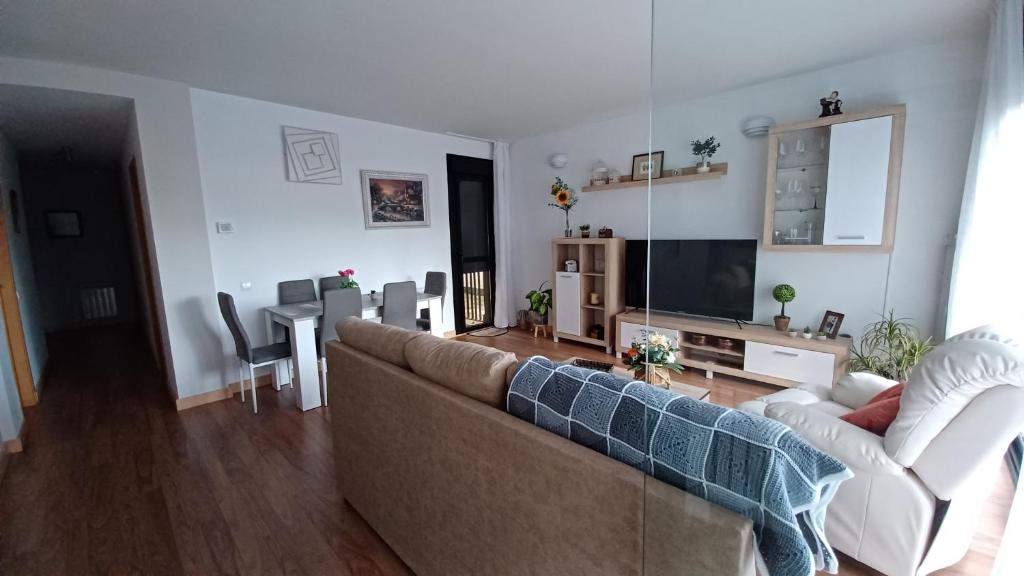 a living room with a couch and a tv and a table at Vivienda Uso Turístico Las Gemelas de Arevalo in Arévalo