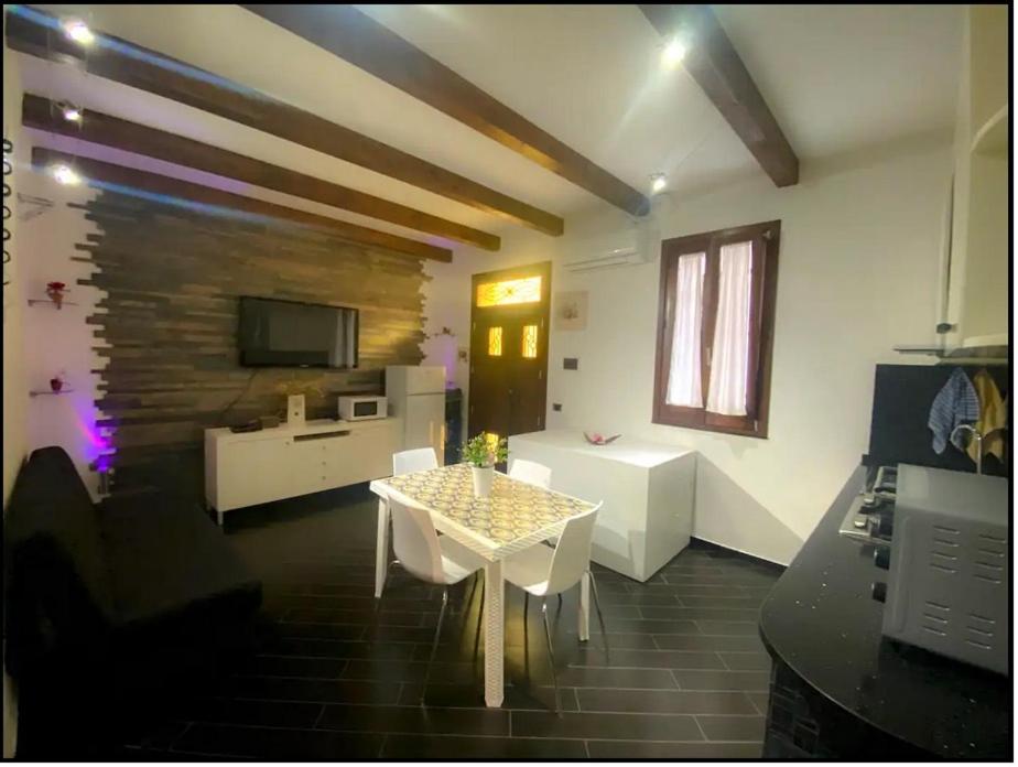 een woonkamer met een tafel en stoelen en een televisie bij Casa Balestrate in Balestrate