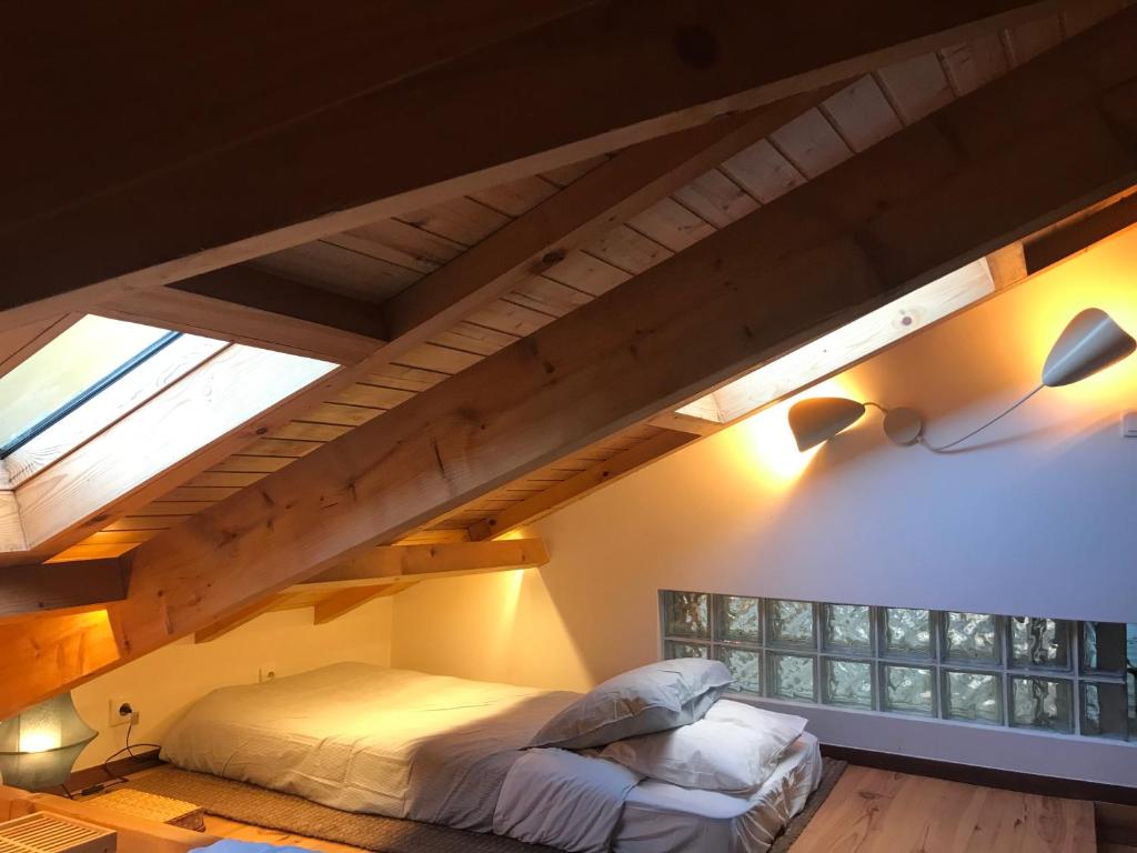 a bedroom with a bed in a loft at Quintinha da Oliveira in Marco de Canavezes