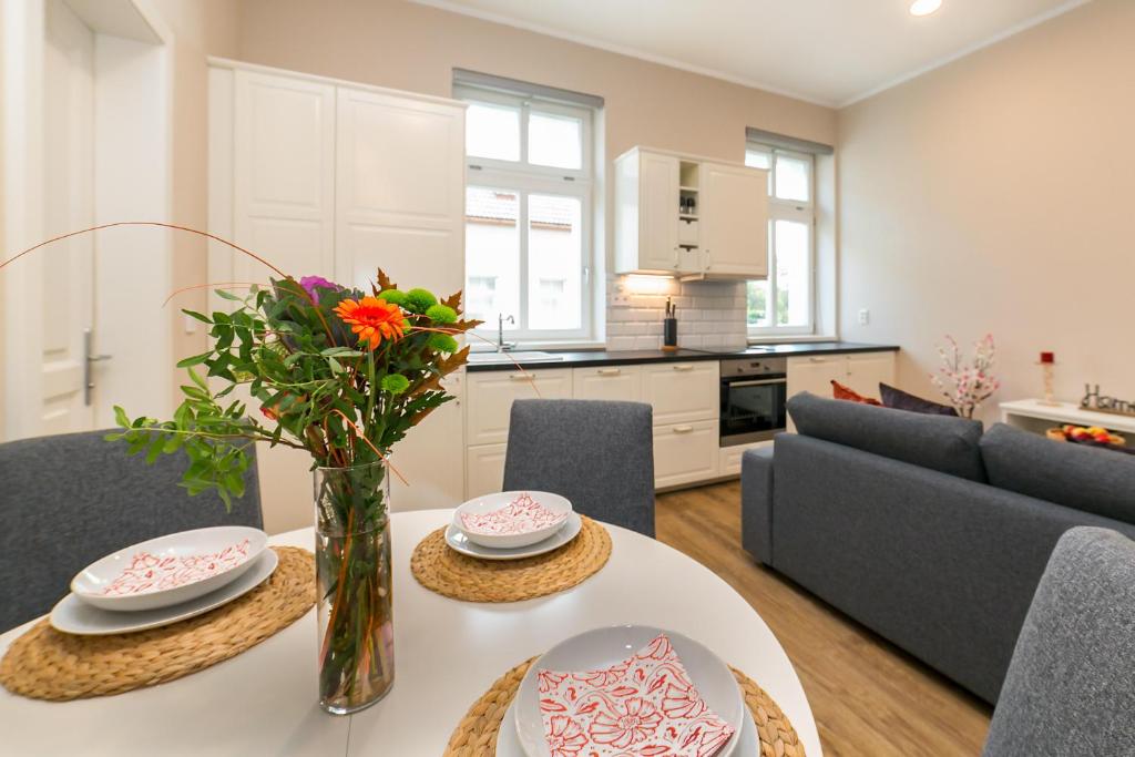 a living room with a table with a vase of flowers at New apartment 2 - self check in, free parking in Bratislava