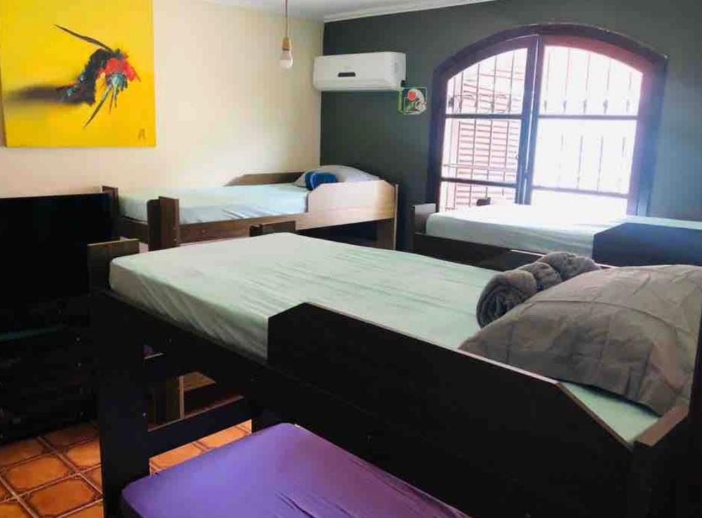 Habitación con 3 camas y ventana en Hostel Guirlanda, en Río de Janeiro