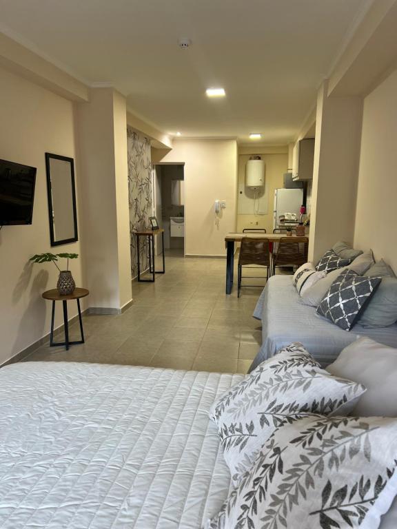 a bedroom with two beds and a living room at Espectacular departamento en pleno centro in Resistencia