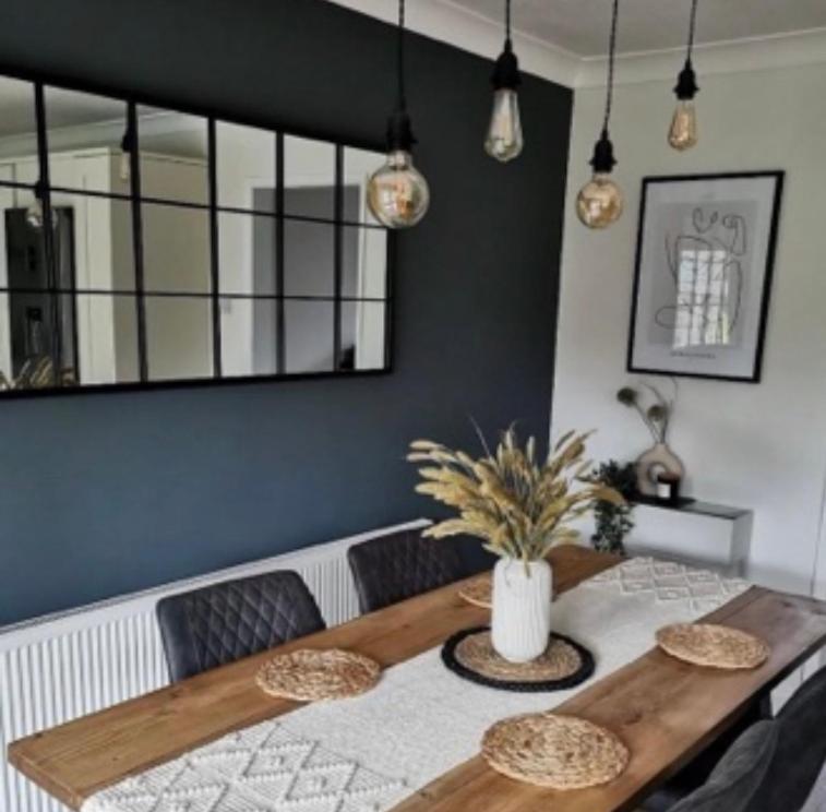 a dining room table with a vase on top of it at Sea Street House in Kent