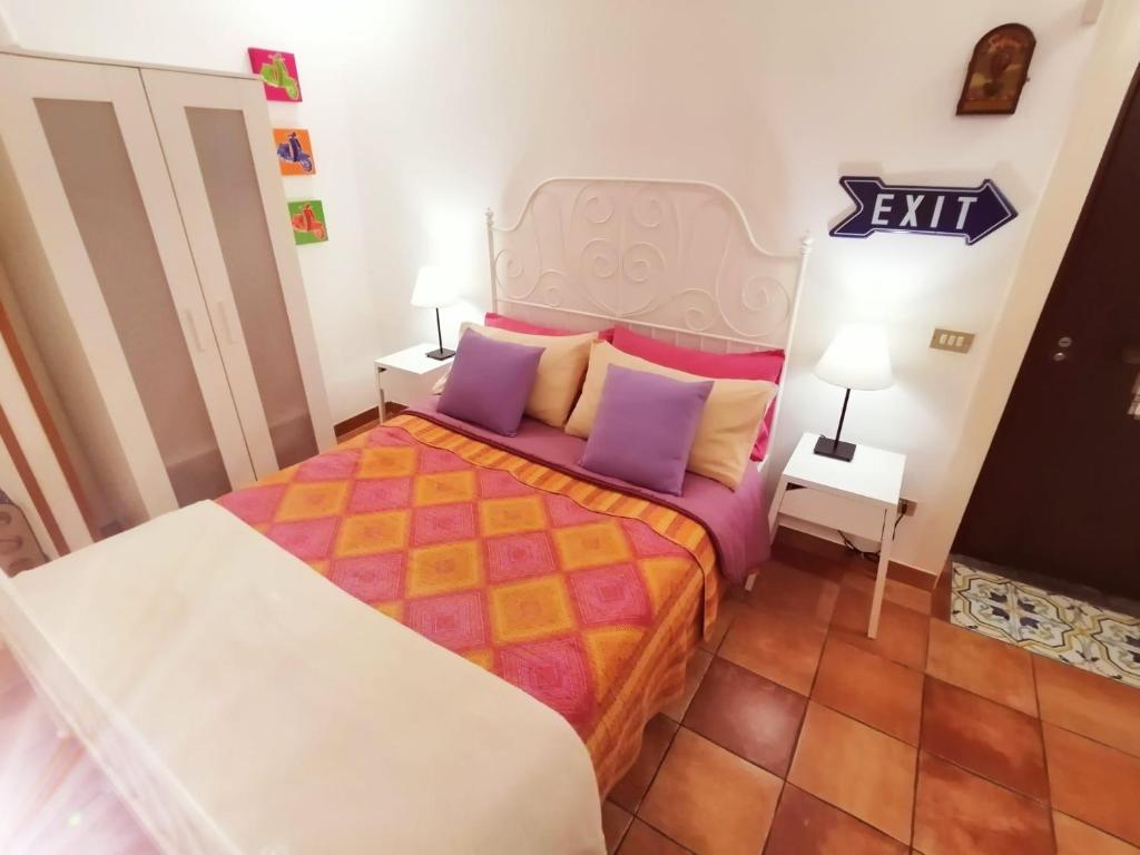 Dormitorio pequeño con cama con almohadas moradas en Blanco's home, en Nápoles