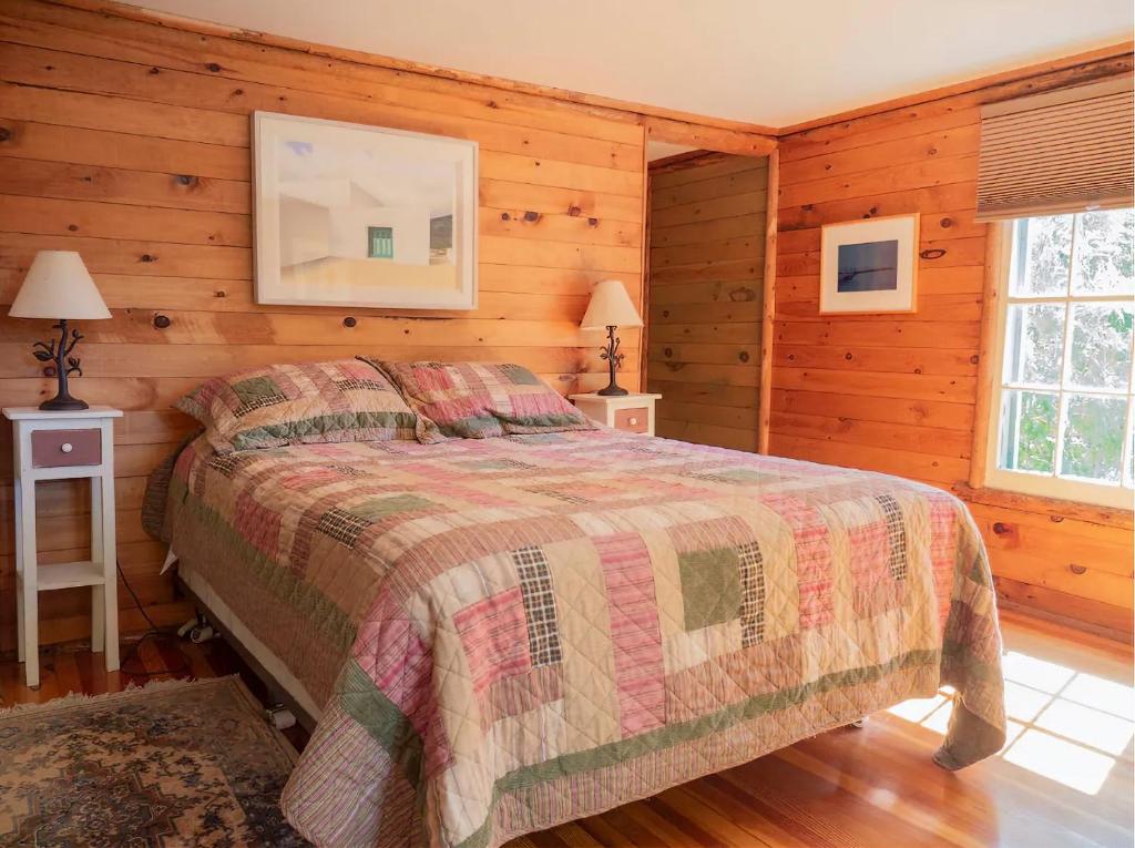 a bedroom with a bed in a log cabin at Adirondack Cottage Retreat in Elizabethtown