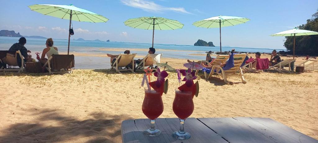 dwa drinki siedzą na stole na plaży w obiekcie Koh Yao Noi Beach Resort w mieście Ko Yao Noi