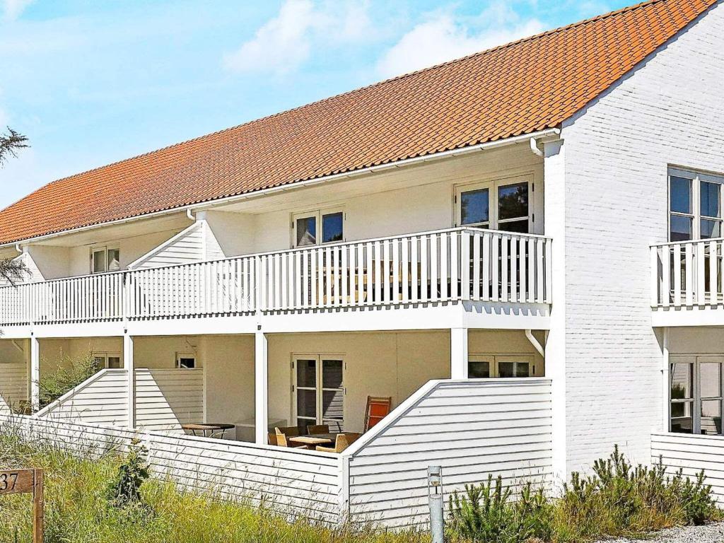 スケーエンにあるHoliday Home Flagbakkevejの白い階段とオレンジ色の屋根の白い家