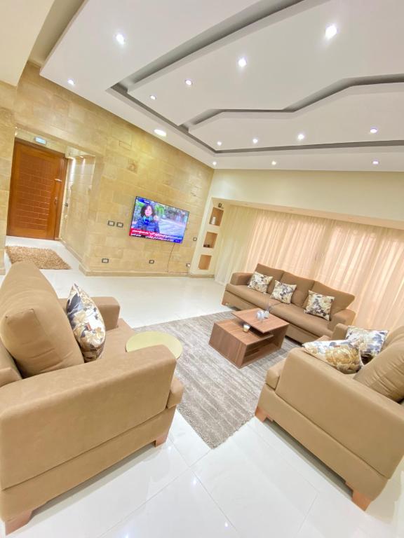 a living room with couches and a flat screen tv at شقه رائعه باطلاله ساحره تواصل قبل الحجز in Cairo