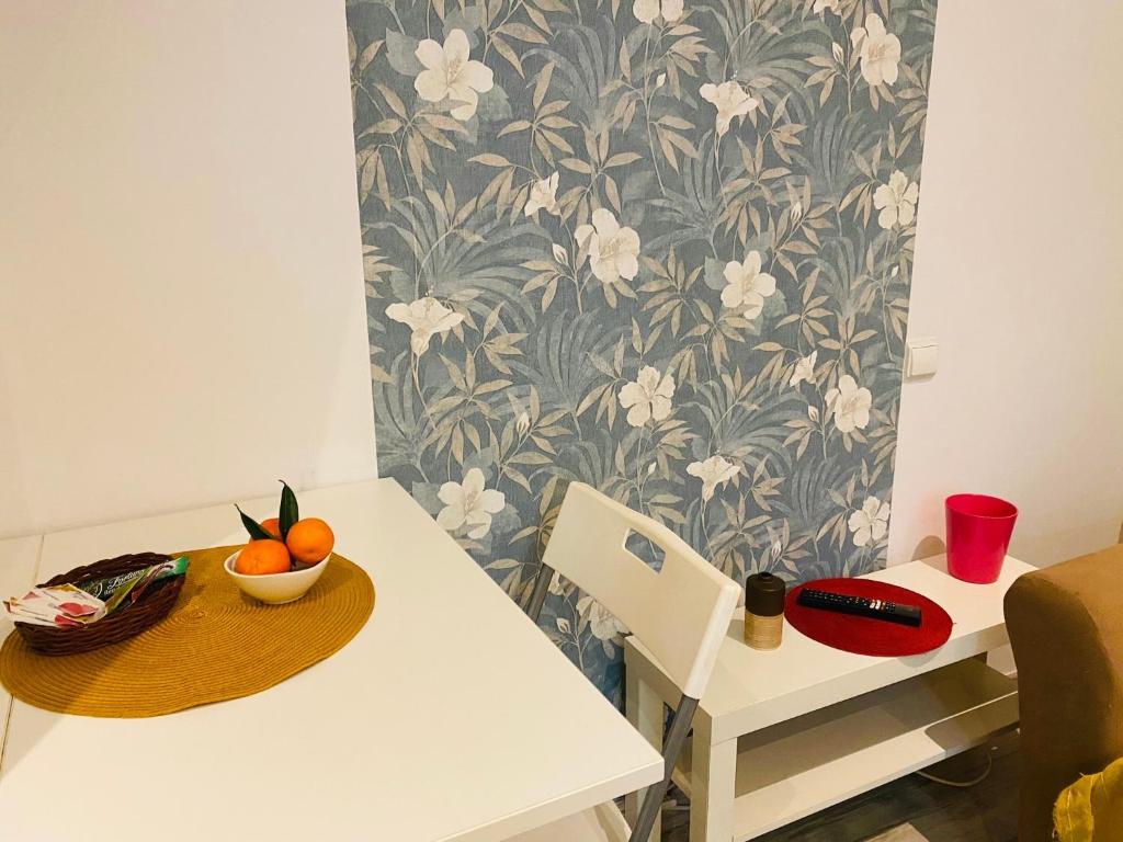 a white table with a bowl of fruit on it at Radisson Charm Studio in Bucharest