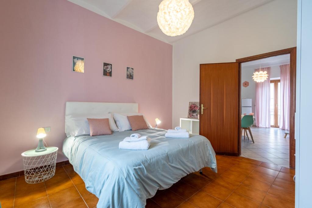 una camera da letto con un letto e due asciugamani di La Verde Rosa - Casa vacanze a due passi dal lago a Marta