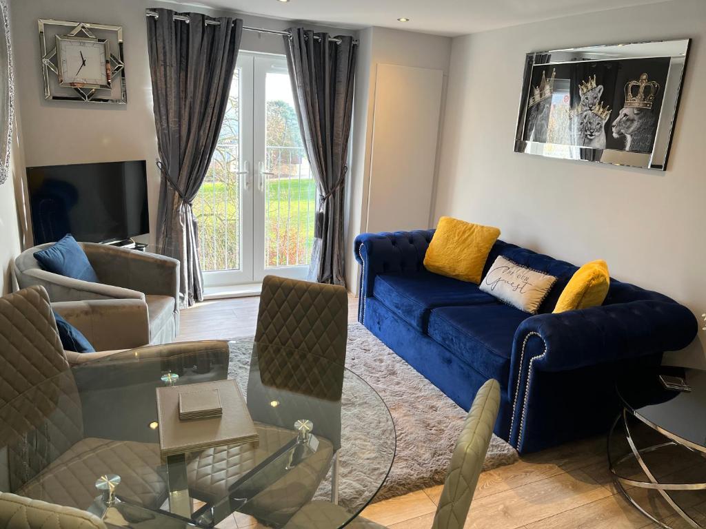 sala de estar con sofá azul y sillas en The Penthouse - Luxury 2 Bed Apartment en Skegness