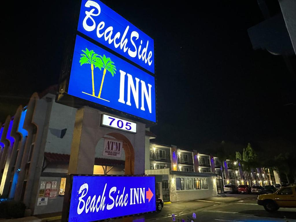 um sinal para um edifício com palmeiras em Beachside Inn em Anaheim