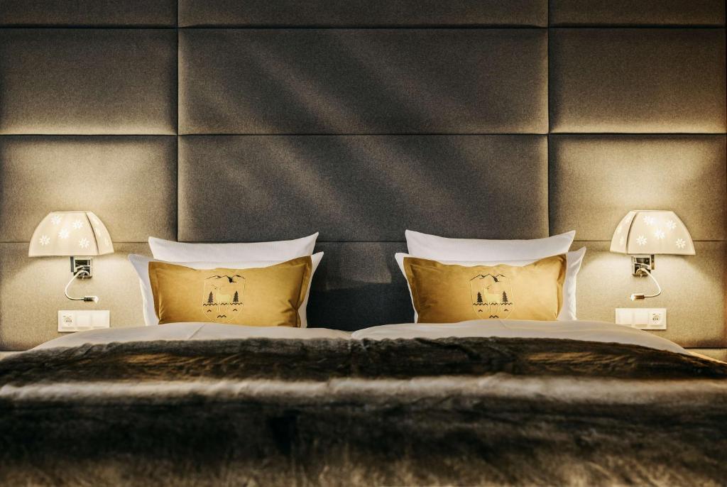 a bedroom with a bed with two lamps on it at Grand Tirolia Kitzbühel - Member of Hommage Luxury Hotels Collection in Kitzbühel