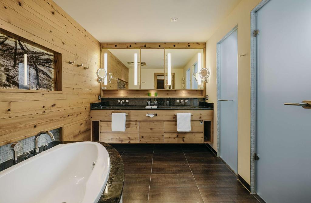 a bathroom with a tub and a large mirror at Grand Tirolia Kitzbühel - Member of Hommage Luxury Hotels Collection in Kitzbühel