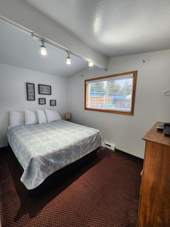 a bedroom with a bed and a window at Plainview Motel in Coos Bay