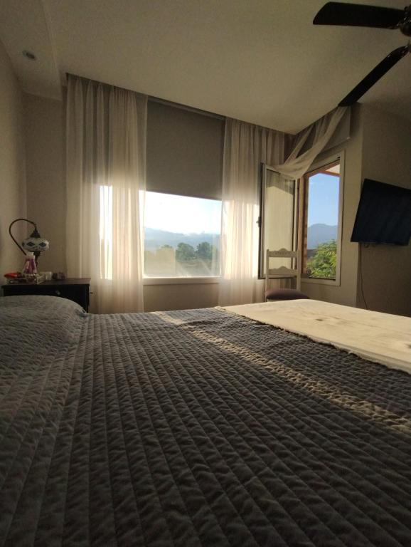 - une chambre avec un grand lit et une grande fenêtre dans l'établissement Morado, à Luján de Cuyo