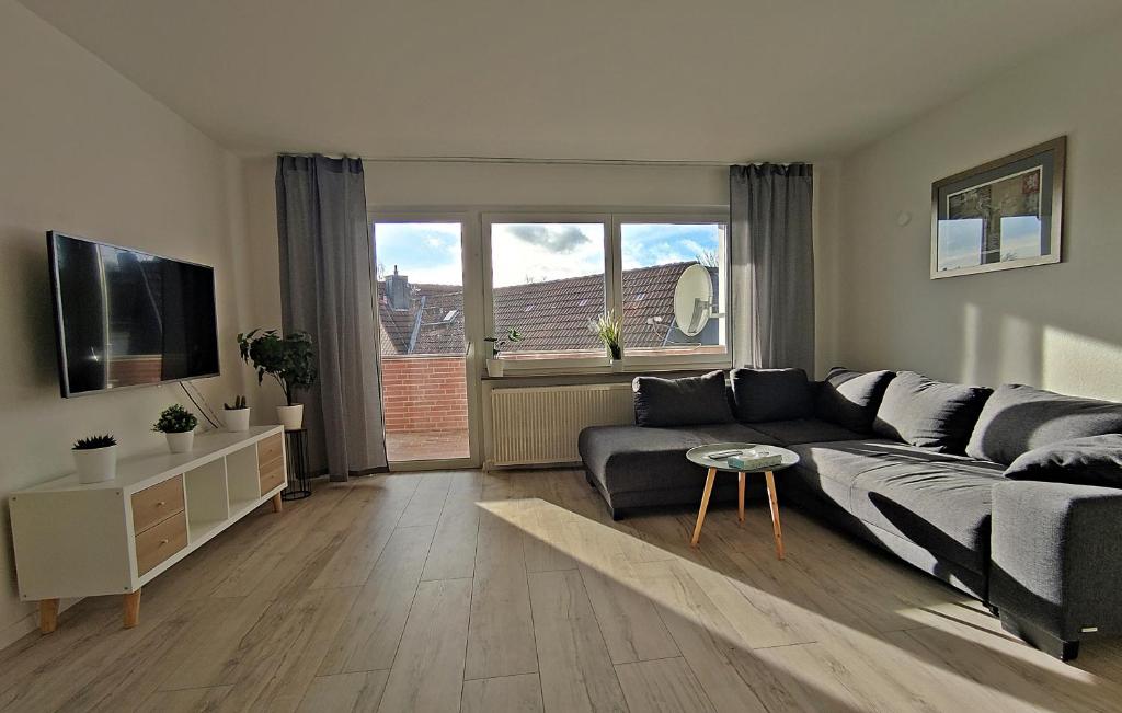Una sala de estar con un sofá y un televisor. en Apartment Weißer Burgunder, en Bad Sachsa