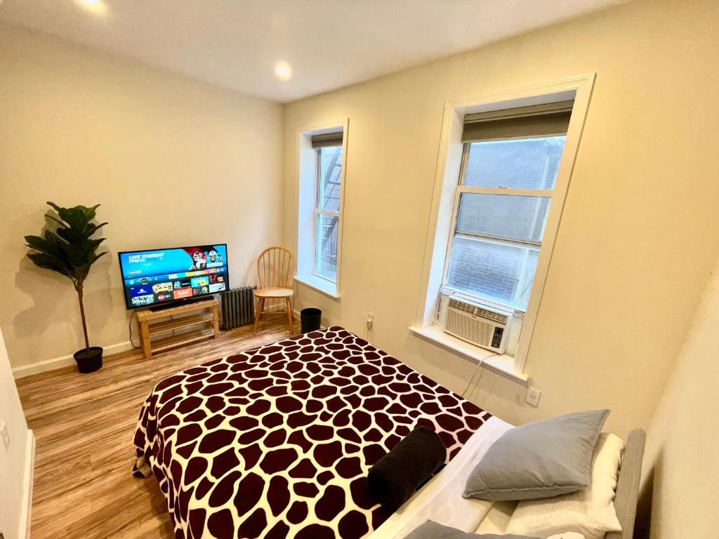 a bedroom with a bed and a flat screen tv at Elegant Private Room close to Manhattan! - Room is in a 2 bedrooms apartament and first floor with free street parking in Long Island City