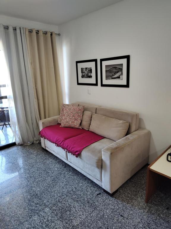 a living room with a couch with a pink blanket at Iracema Flat 2102 Beira Mar in Fortaleza